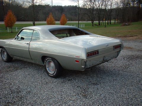 1971 Ford Torino - Silver 1971 Ford Torino coupe parked on gravel with trees in the background.