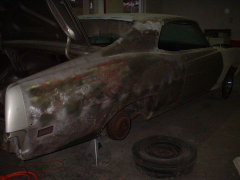 1971 Ford Torino - A car body, possibly a 1970s model, is undergoing restoration with visible primer and rust.