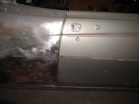 1971 Ford Torino - Side view of a 1971 Ford Torino door panel showing bodywork in progress and a red stripe trim.