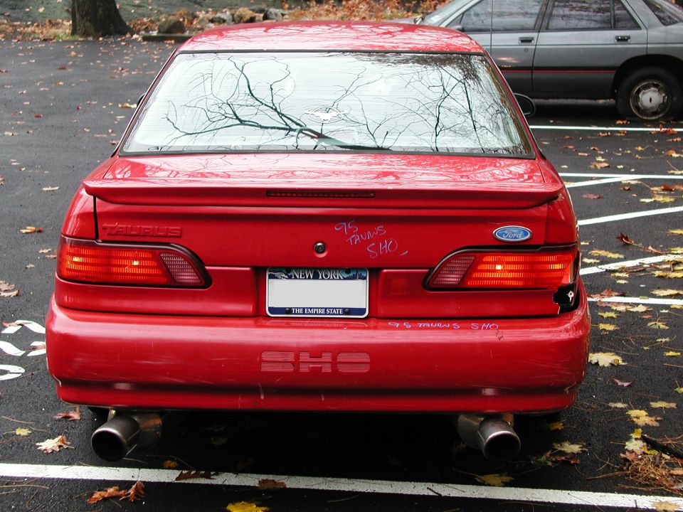 Red 1995 Ford Taurus SHO rear view with dual exhaust and New York license plate
