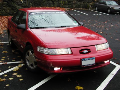 1992 Ford Taurus - Red 1992 Ford Taurus sedan parked in a lot with fall leaves on the ground.