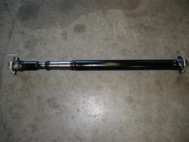 black driveshaft with u-joints on concrete floor