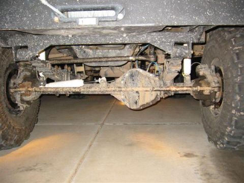 1994 Ford Bronco - Undercarriage view of a lifted 4x4 vehicle's front axle and suspension system.