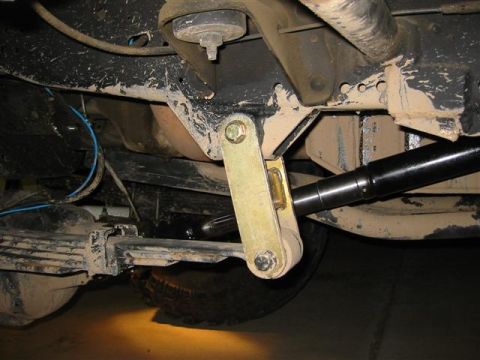 1994 Ford Bronco - Close-up view of a vehicle's suspension system, showing leaf springs and a shock absorber.