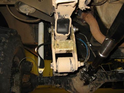 1994 Ford Bronco - Close-up view of the undercarriage, showing suspension components, a driveshaft, and a large tire.