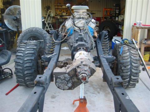1994 Ford Bronco - The chassis of a vehicle is shown with its engine and drivetrain components, undergoing assembly or repair.