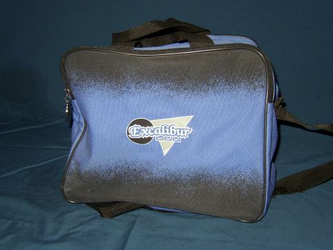 1987 Volkswagen Golf - Duffel bag with Excalibur logo and strap on a blue background.