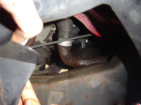 1998 Ford Taurus - A close-up view reveals a rusty hose and various metal engine components, suggesting a need for maintenance.
