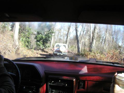 1988 Ford Bronco - Driving off-road in a 1988 Ford Bronco, following another SUV through a wooded area.