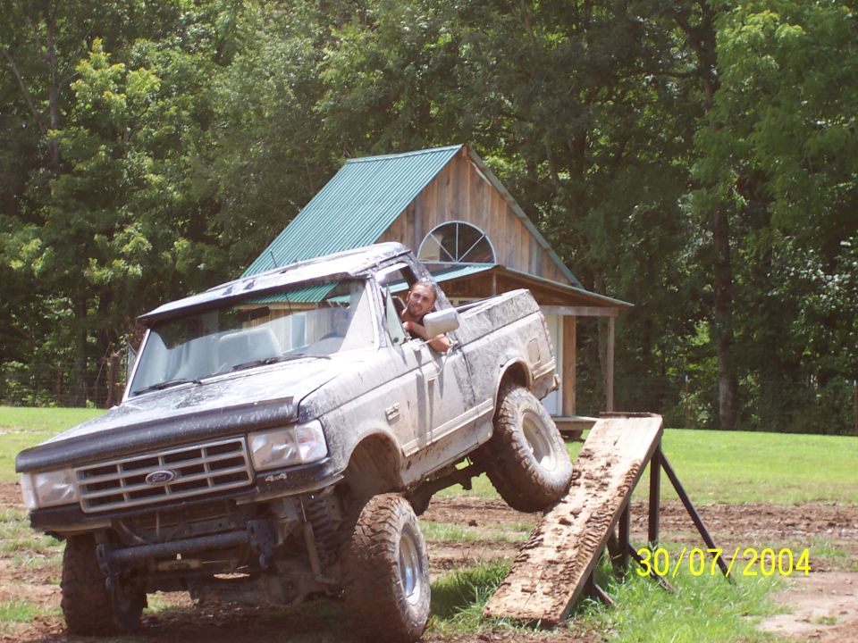 Gray Ford F-Series truck with front wheel off the ground on a wooden ramp