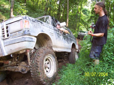 1979 Ford F-150 - A lifted 1979 Ford F-150 navigates a muddy trail with another vehicle visible in the background.