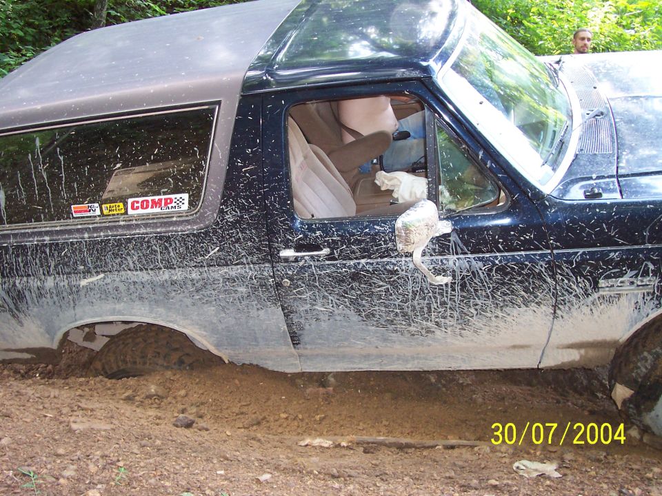 Mud-covered 1979 Ford Bronco stuck in dirt, side view. Date stamp 30/07/2004