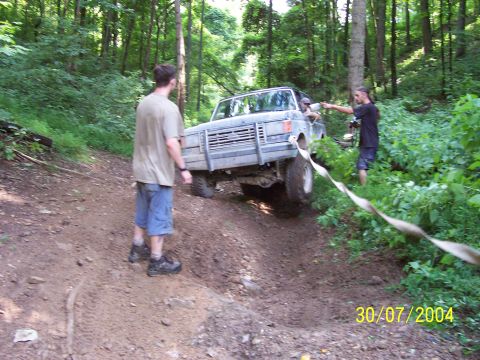 1979 Ford F-150 - A gray truck navigates a steep dirt path in a wooded area.