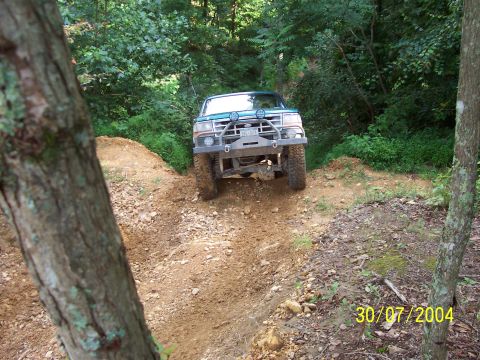 1979 Ford F-150 - A green Ford F-150 navigates an off-road trail, its front end angled towards the camera.