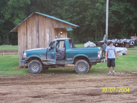 1979 Ford F-150 - Green Ford Bronco parked outside a wooden structure on a dirt lot.