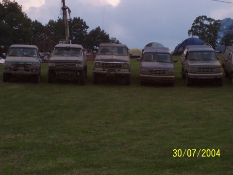 1979 Ford F-150 - Several trucks are lined up on a grassy field with tents visible in the background.