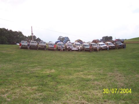 1979 Ford F-150 - Multiple off-road vehicles are parked in a field, with tents set up behind them.