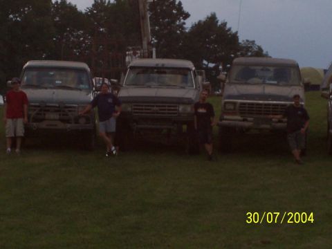 1979 Ford F-150 - Three trucks are parked in a field with two people standing in front of them.
