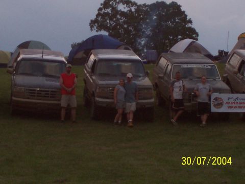 1979 Ford F-150 - Several Ford Broncos are parked at a campsite with tents set up in the background.