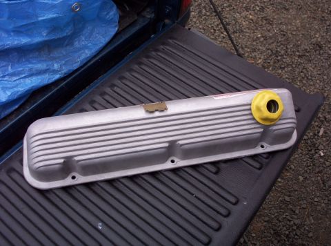 1991 Ford LTD Crown Victoria - A silver aluminum valve cover with a yellow oil cap sits on a black truck bed liner.