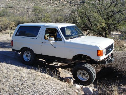 1987 Ford Bronco - The right rear is about 2" from the bumpstop, but the inside edge of the tire is rubbing hard on the wheel well due to the angle.