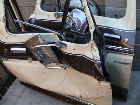 1979 Ford Bronco - Two removed truck doors leaned against a block wall, painted cream over dark brown with a two-tone pinstripe, chrome trim and chrome West C…