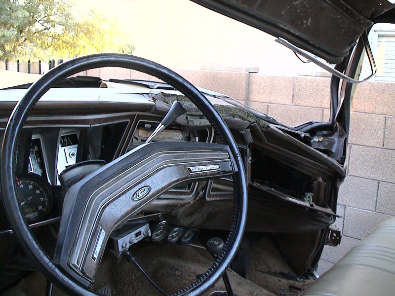 Ford truck driver's dash with two-spoke wheel, woodgrain trim, add-on tach and cracked dash pad