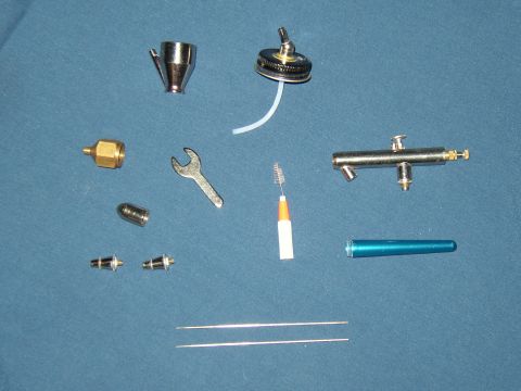 1987 Volkswagen Golf - Various components and tools for an airbrush are displayed on a blue background.