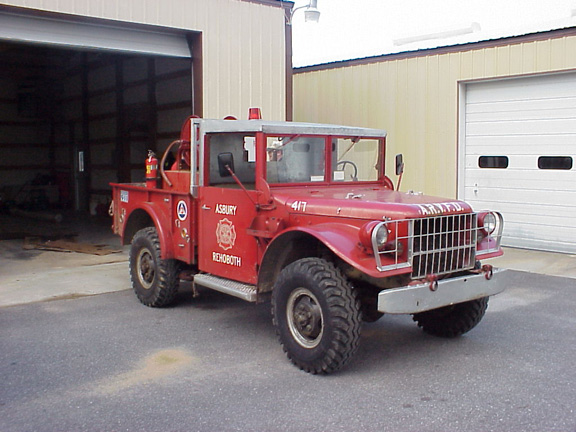 Red fire truck with 'ASBURY REHOBOTH 417 A.R.Y.F.D.' markings parked in front of a garage