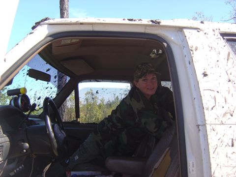 1993 Ford Bronco - Woman sits inside a mud-covered white SUV, with a gauge visible on the dashboard.