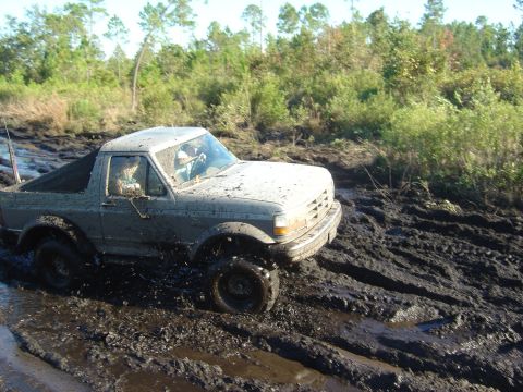 1993 Ford Bronco - This mud-splattered Ford Bronco is struggling to navigate through a very muddy terrain.