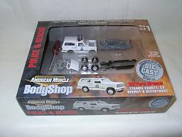 1979 Ford Bronco - This American Muscle BodyShop kit features unassembled police and rescue vehicle parts, including a van and truck, for customization.