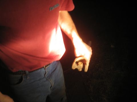 1981 Ford Bronco - A person holds a metal component, illuminated by a light source in the darkness.