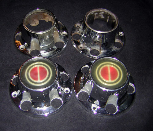Four chrome hubcaps with red and gold center emblems, two with visible mounting studs