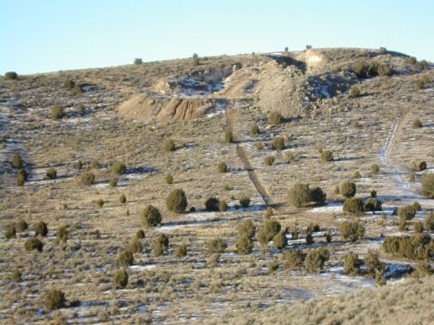 1994 Ford Bronco - A wide view of a desert terrain with multiple dirt paths winding through sparse vegetation and patches of snow.