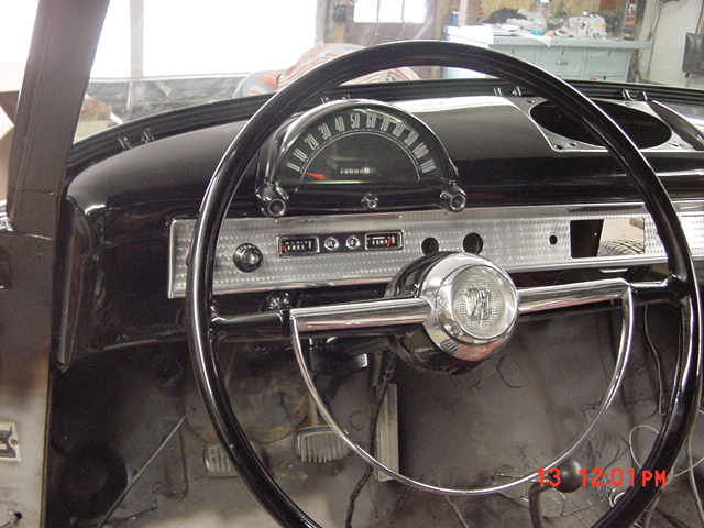 Classic car interior with chrome two-spoke steering wheel and ribbed metal dashboard