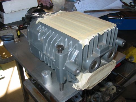 1993 Ford Taurus - A gray supercharger sits on a metal workbench, partially covered with masking tape.