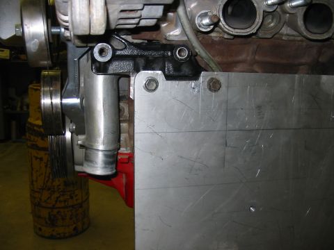 1993 Ford Taurus - Close-up view of an engine component with a bolted metal plate and pulley system.