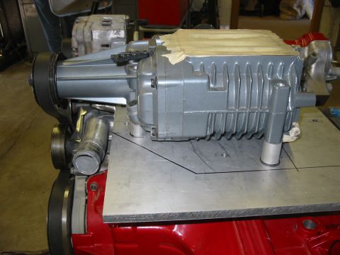 1993 Ford Taurus - A supercharger assembly is shown mounted on a metal plate, with a red engine block visible below.