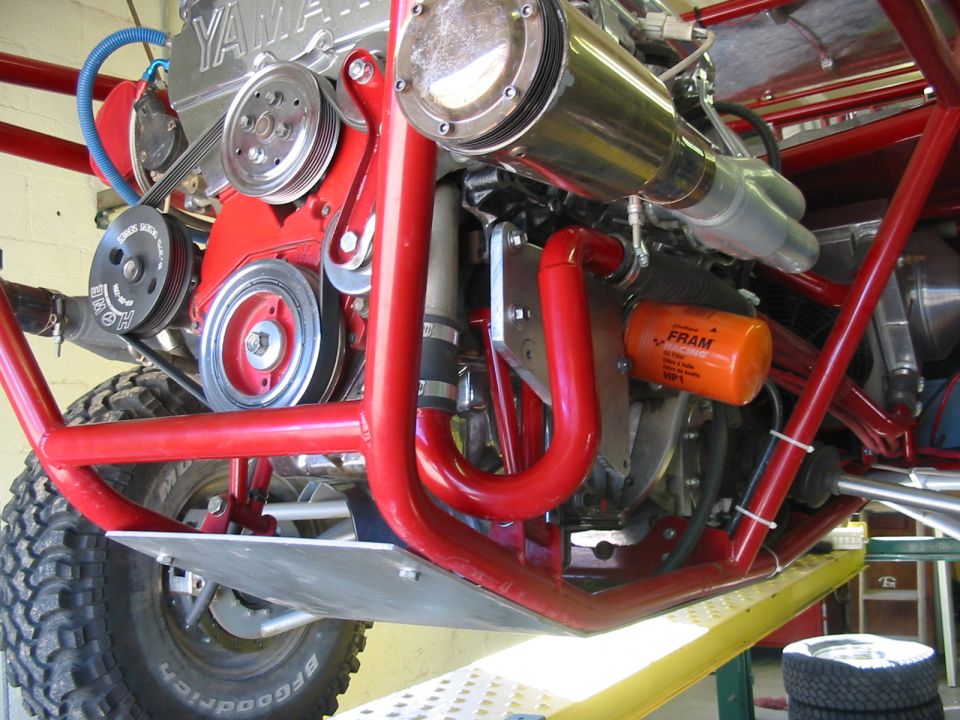 Close-up of a red-tubed off-road buggy engine with a Yamaha cover and Fram oil filter