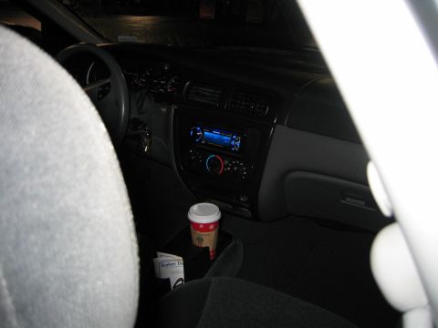 2002 Ford Taurus - Interior view of a 2002 Ford Taurus, complete with coffee and an aftermarket stereo system.