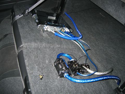2002 Ford Taurus - Custom car audio equipment, including an amplifier and wiring, is installed on the rear seat of the vehicle.