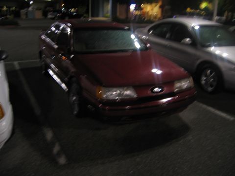 2002 Ford Taurus - Maroon Ford Taurus parked at night with another car beside it.