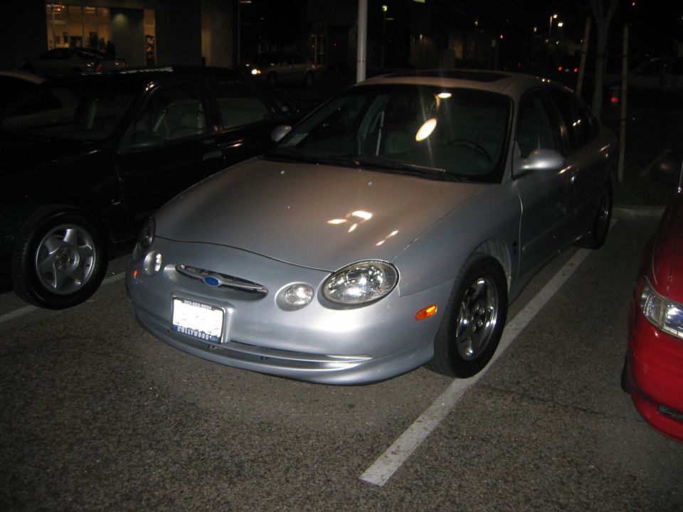 Silver 2002 Ford Taurus front view with a black car to the left