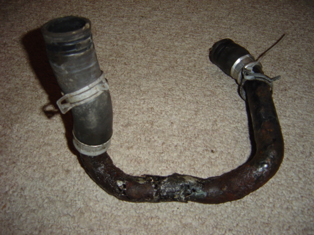 rusted metal pipe with rubber hoses and clamps