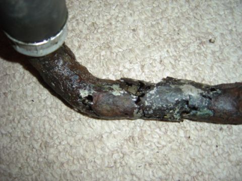 1998 Ford Taurus - This corroded pipe and hose assembly shows significant wear and damage.