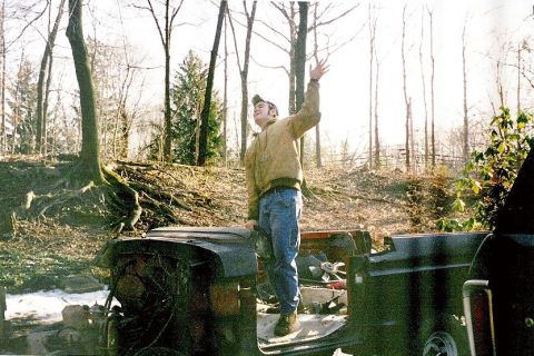 1978 Ford Bronco - A man stands in the interior of a dilapidated 1978 Ford Bronco, waving his hand.