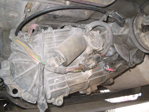1991 Ford Bronco - Underside view of a vehicle's transfer case and transmission components with visible wiring.