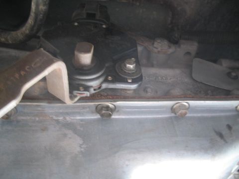 1991 Ford Bronco - A close-up view of the transmission shift linkage and pan of a vehicle.