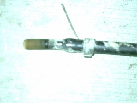 1995 Ford Bronco - A close-up view of a mechanical component, possibly a linkage or rod, with visible wear and grime.
